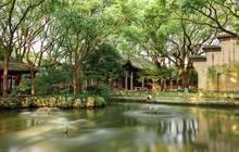 brown wooden house near green trees and river during daytime © Jerry Bao 